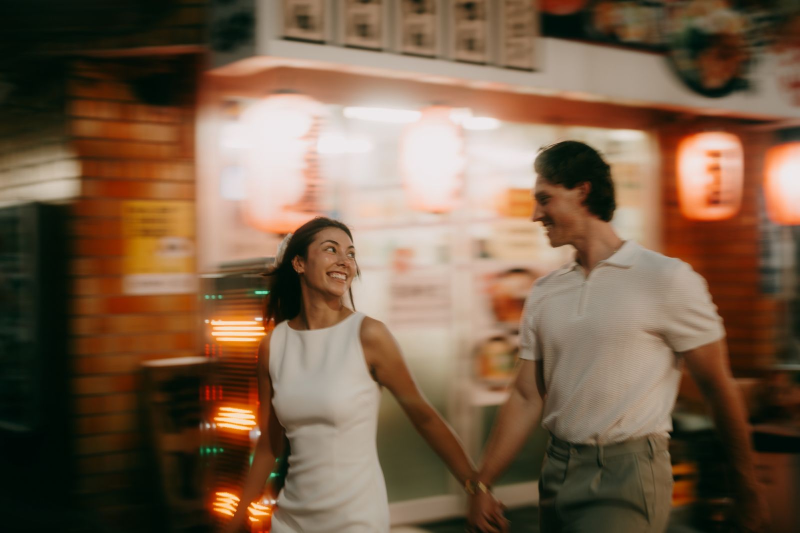 Young couple having a great time in Tokyo backstreet alley with izakaya at night
