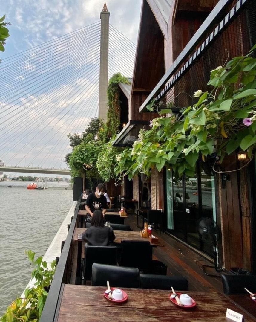 โซนที่นั่งเอาท์ดอร์พร้อมวิวแม่น้ำเจ้าพระยาและสะพานพระราม 8 จากร้าน Rama8 Café (ภาพ: Facebook.com / @Rama8Cafe)