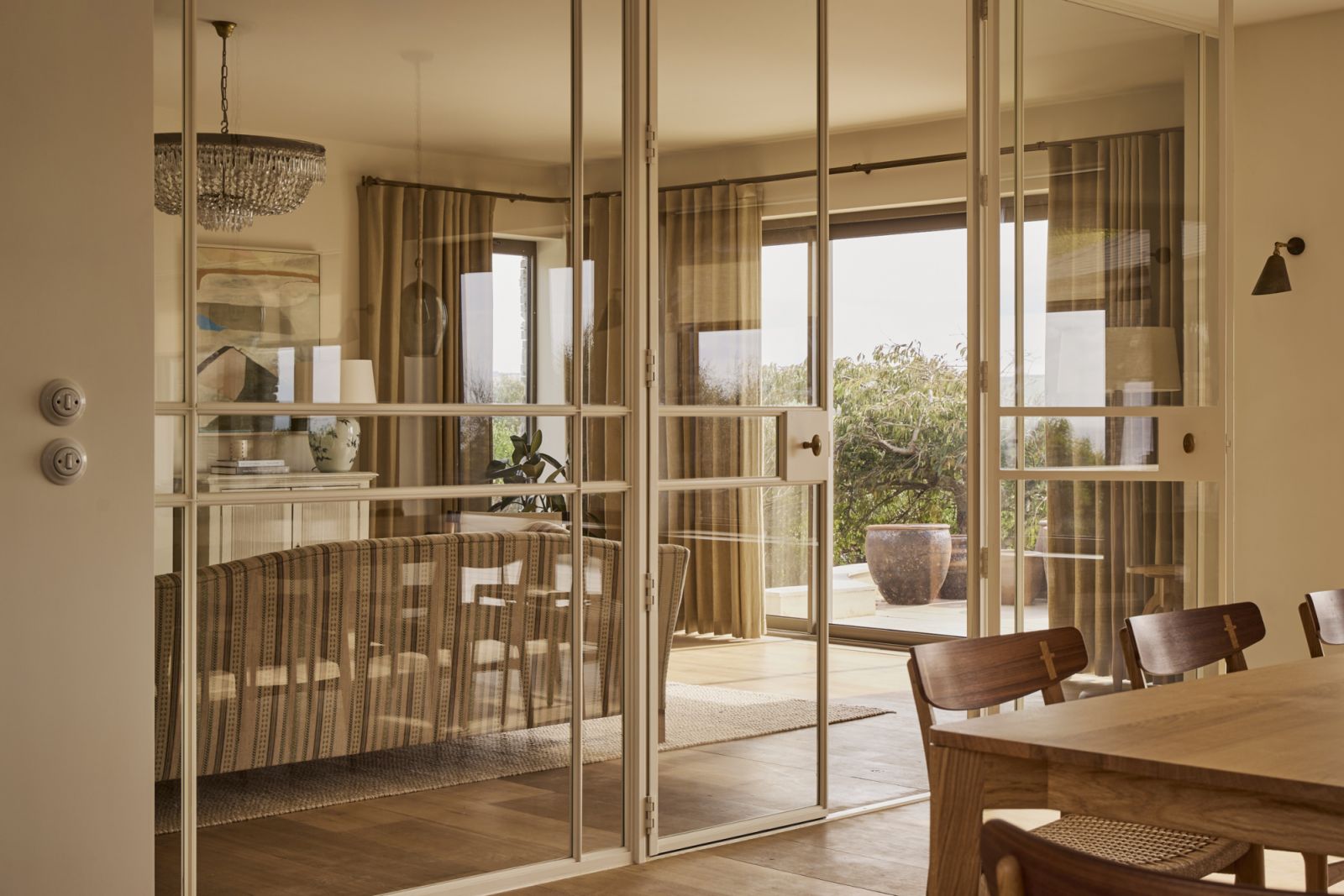 The custom-designed floor-to-ceiling glazing with off-white powder-coated metal frames