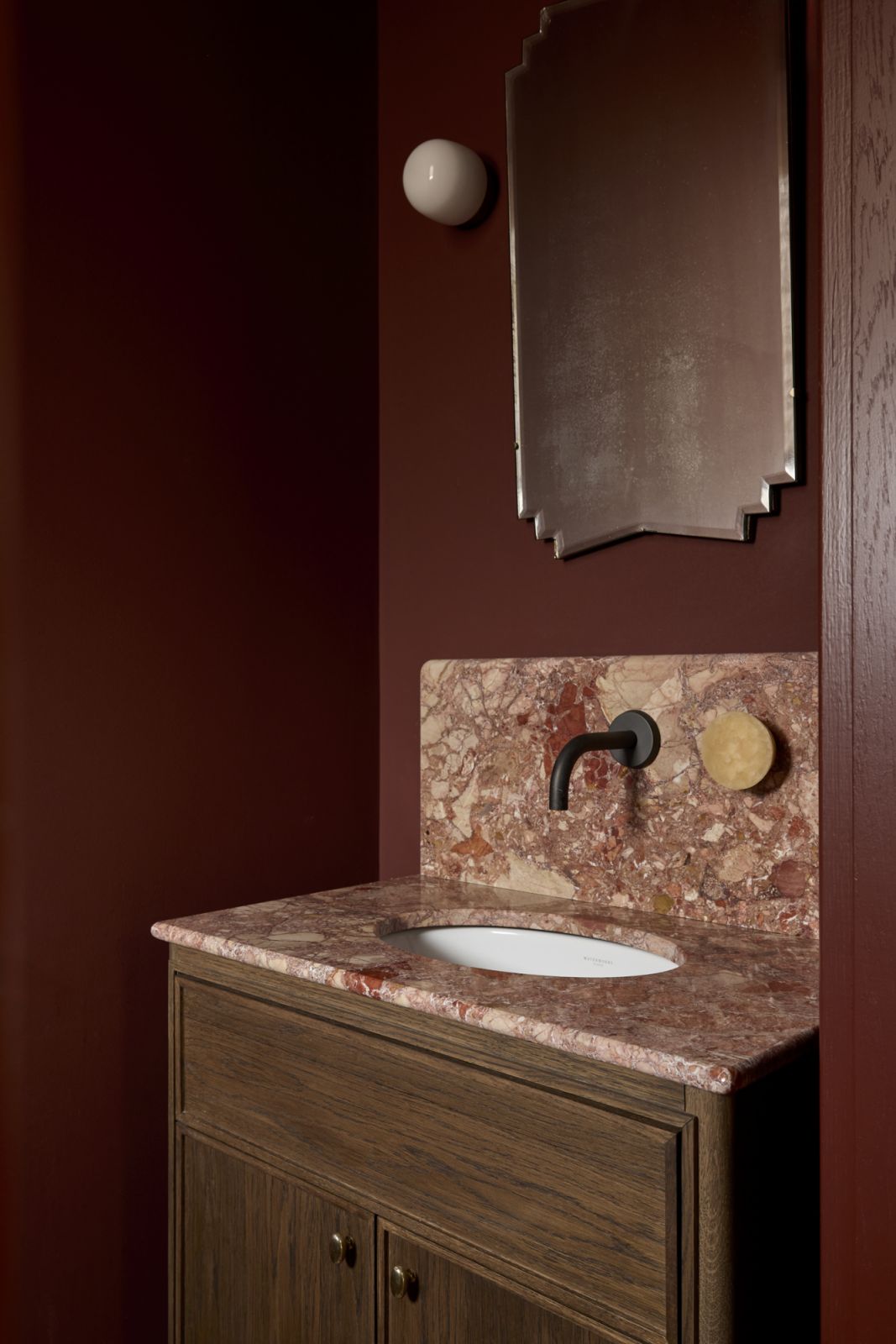 One of the two powder rooms in Farrow & Ball’s Brinjal with a matching vanity