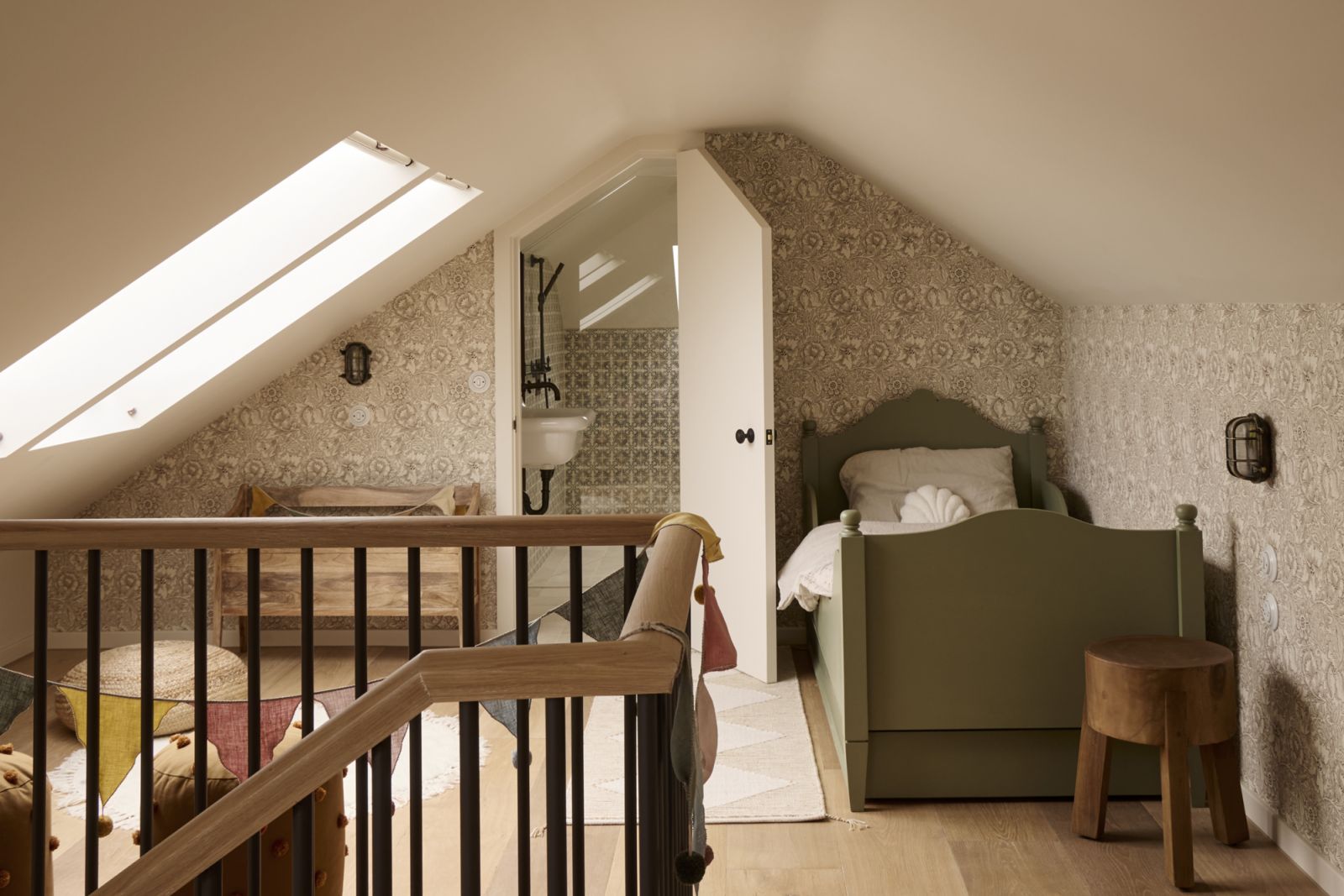 The attic bedroom clad in Morris & Co by Sanderson’s poppy wallpaper