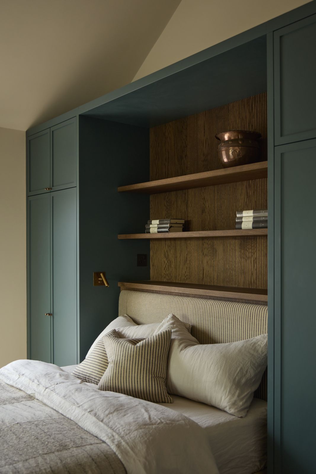 The guest bedroom with with a striped fabric headboard and bespoke joinery in Inchyra Blue