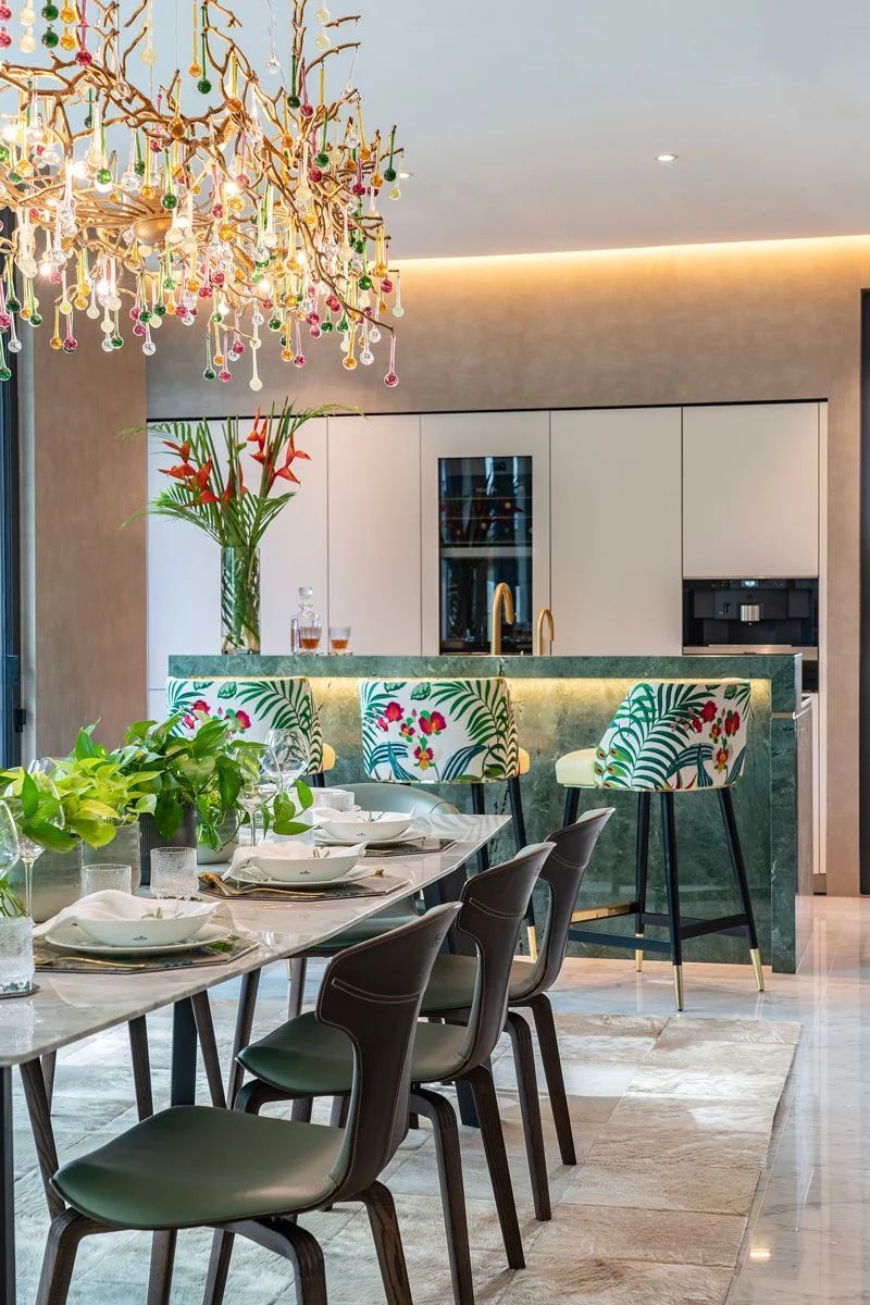 A marble bar counter in a rich emerald hue anchors the open plan