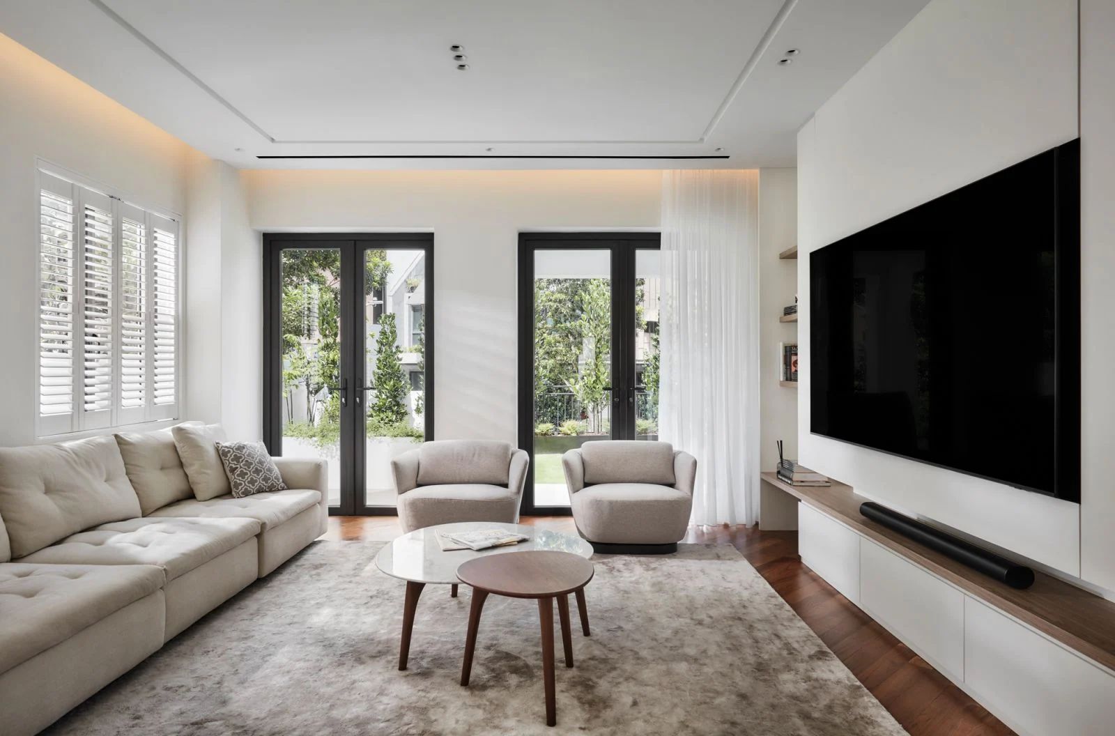 The downstairs living room adjoins the entryway of the home with a refreshed, modern staircase