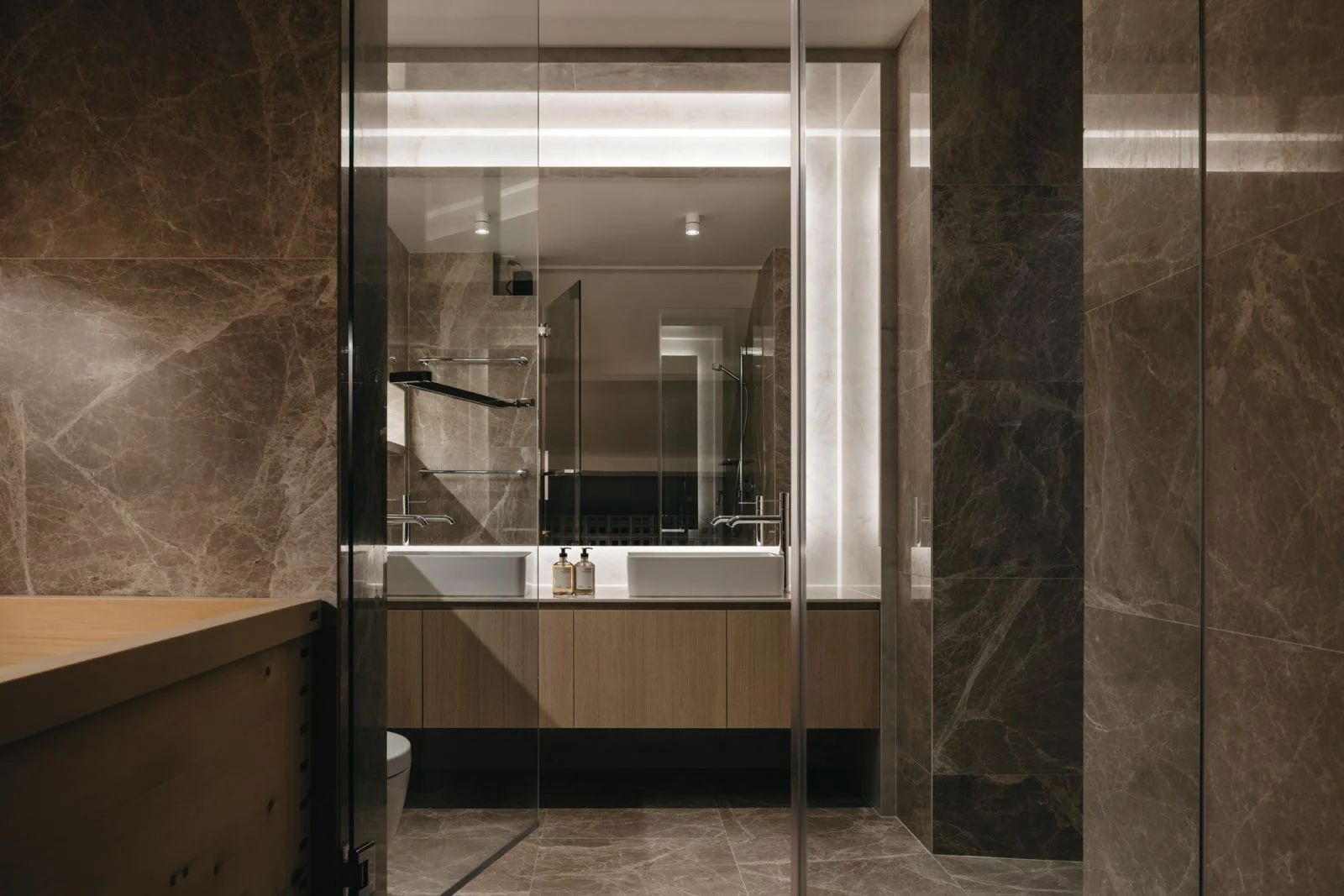 The stately bathroom features a Hinoki wood bathtub and elegant stone finishes