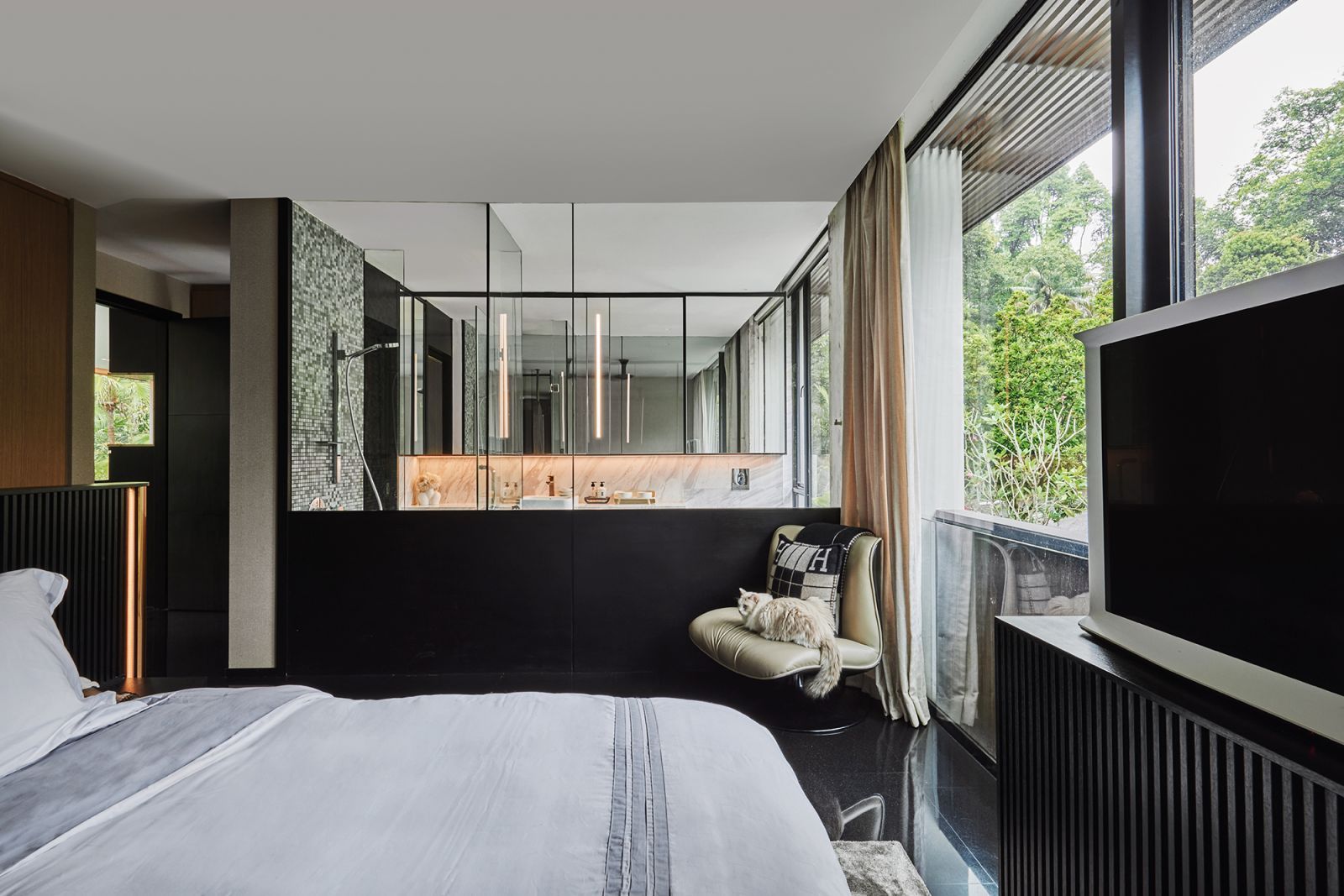 Encasing the ensuite bathroom in glass creates a sense of visual continuity with the bedroom