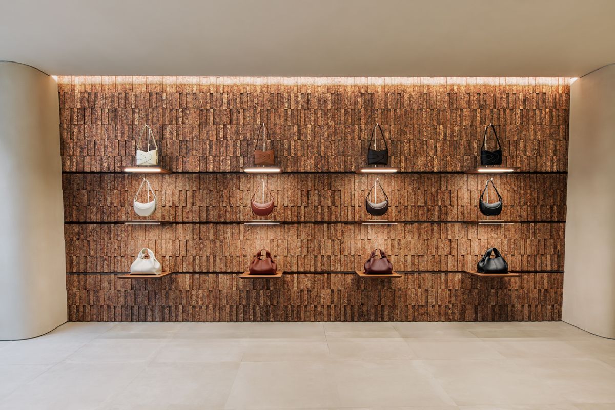 The rich, tactile background of the bag display at Polène London