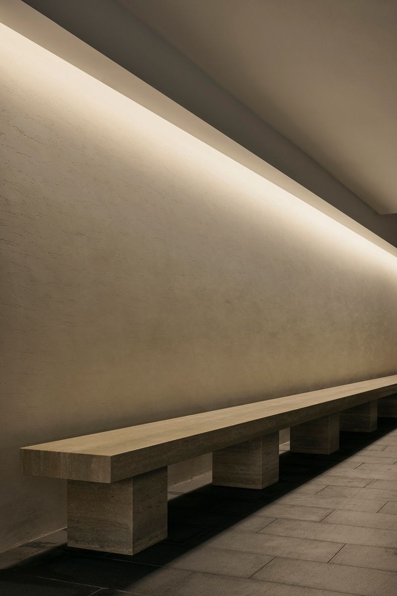 The basement features a long travertine bench and an artificial skylight