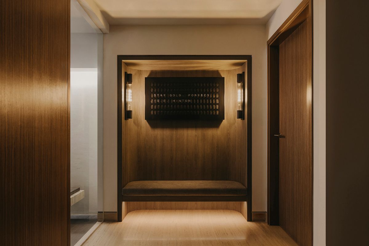 This corridor terminates in a sitting area with typographic artwork in dark-stained oak