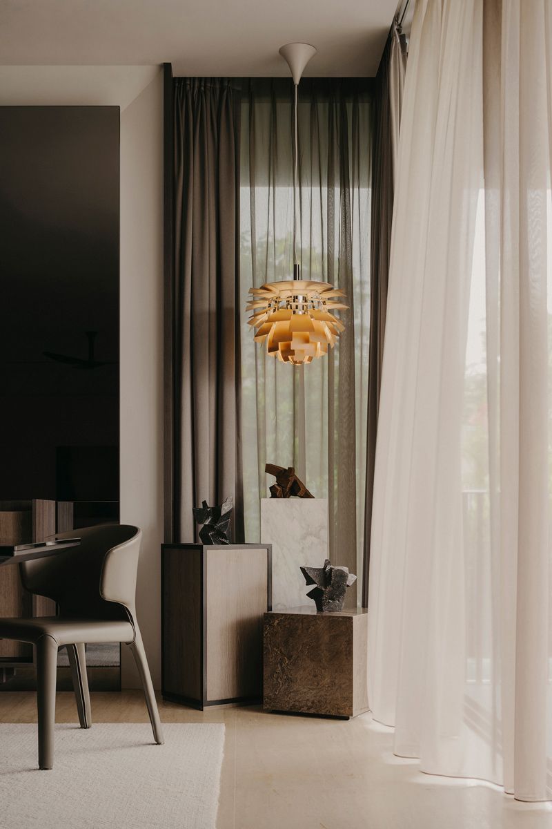 Above the pedestal, a Louis Poulsen Artichoke lamp glows subtly