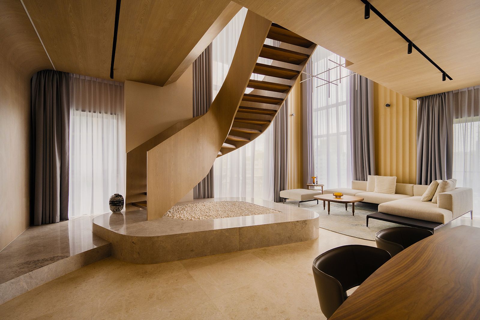 The sculptural “oculus” staircase is the focal point of the living hall in this Orchard home