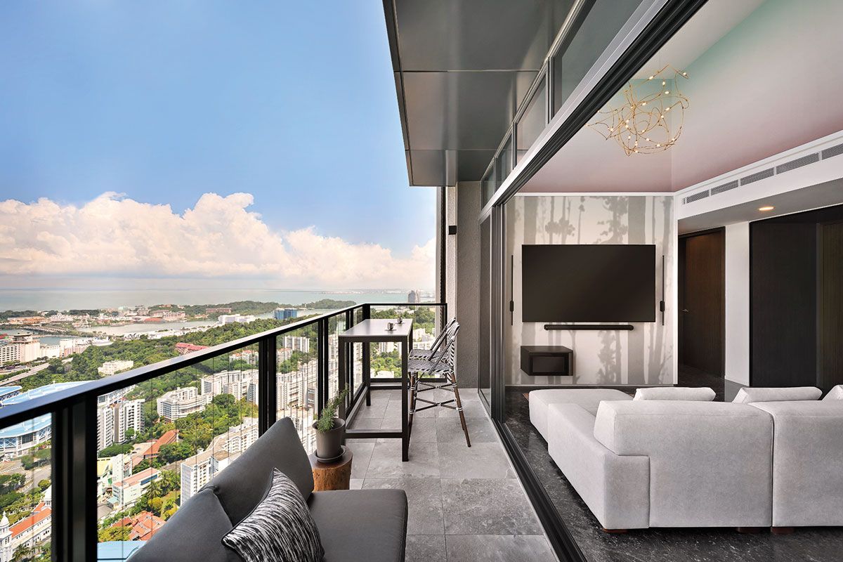 The living room seamlessly opens out to the balcony, which also features a stylish bar-height seating corner