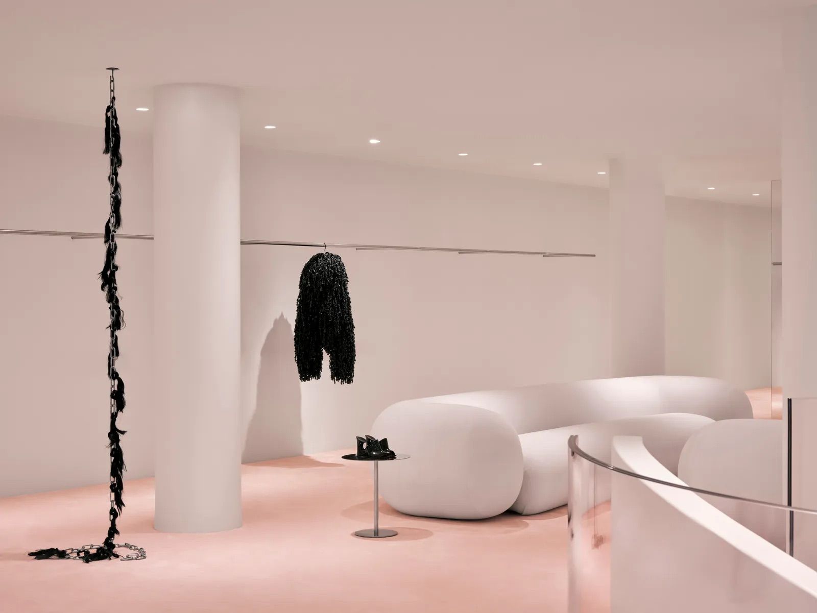 The pristine white interior showcases organic-shaped seating elements and cylindrical columns (Photo: Alaïa)
