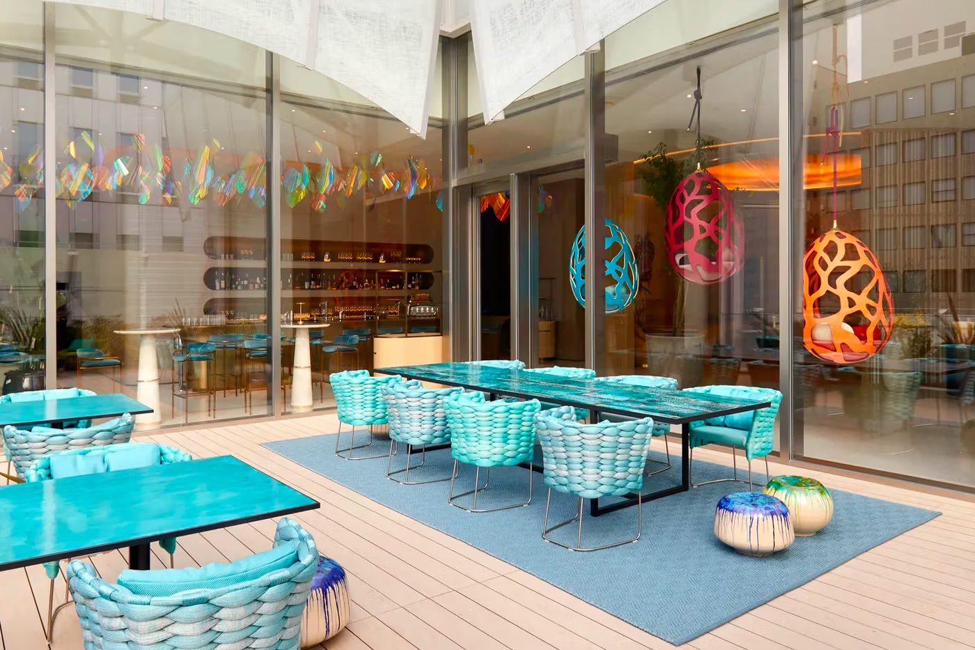 The outdoor terrace features woven aqua dining chairs for a light breezy feel (Photo: Louis Vuitton)