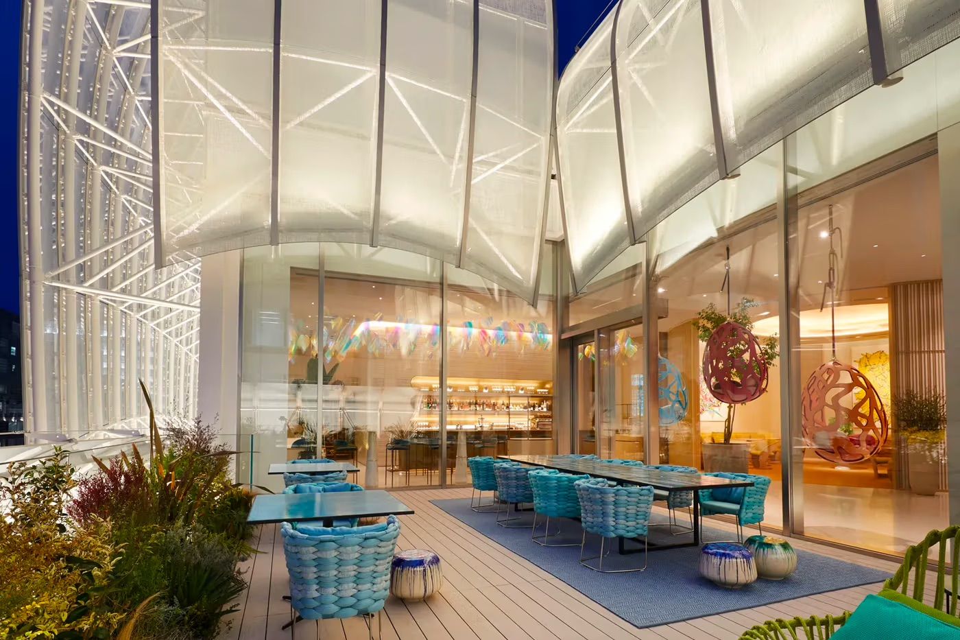The architectural façade of Le Café V with its distinctive billowing sail-like structure (Photo: Louis Vuitton)