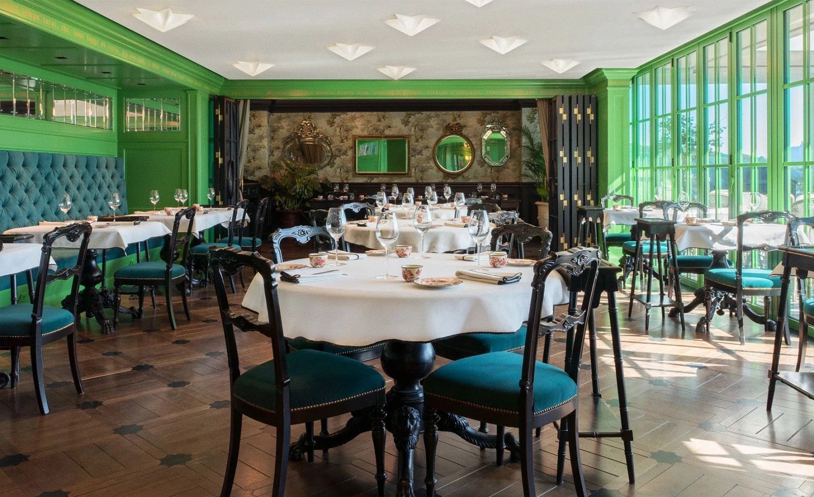 The main dining room bathes in natural light from expansive windows framed in the signature Gucci green (Photo: Gucci)