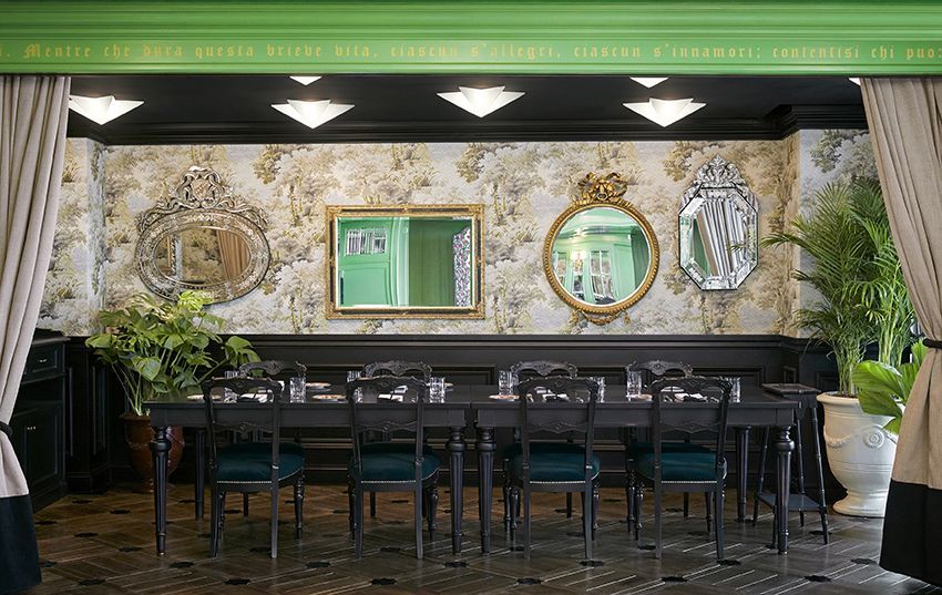 The floral wallpaper, ornate mirrors, and lush potted plants create a richly layered environment that echoes the brand’s decorative sensibility (Photo: Gucci)