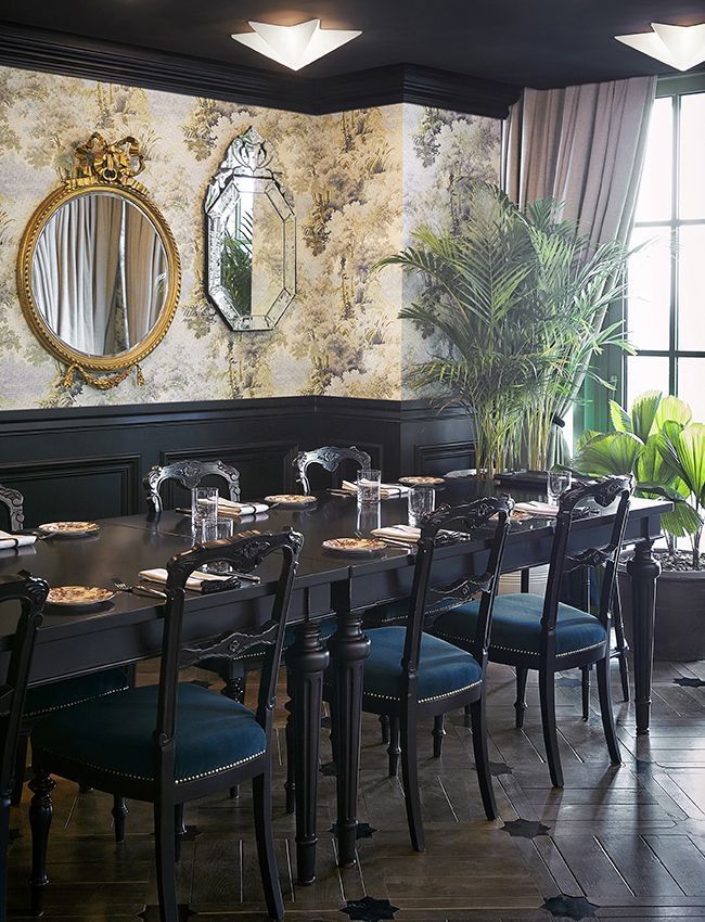The dining room features deep green velvet chairs surrounding a black lacquered table (Photo: Gucci)