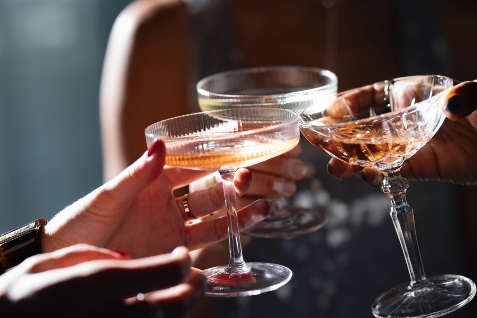 Unrecognizable group of multi-ethnic peoples having fun together at Christmas party and toasting with alcohol.
