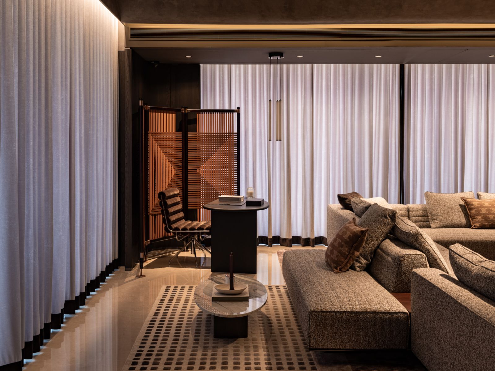 In this deliberate corner composition, an armchair creates an intimate moment within the expansive living area