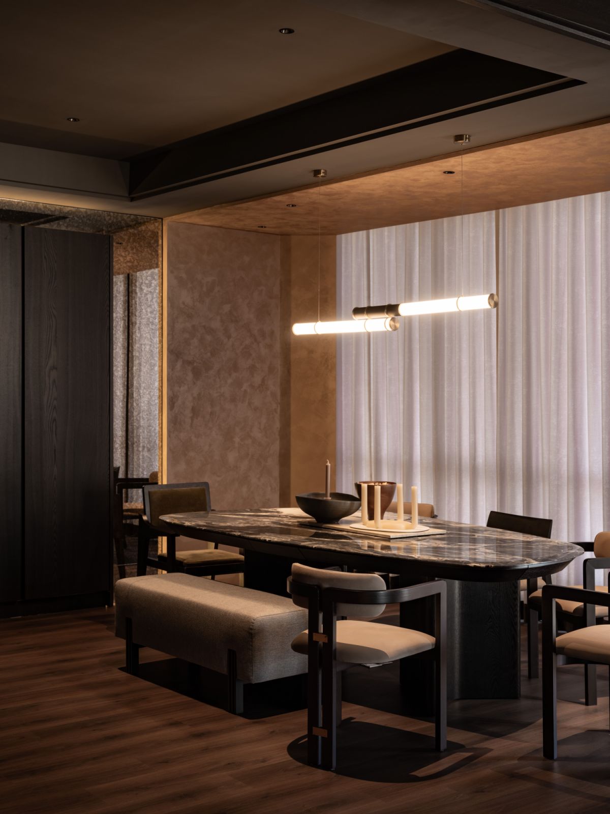 The dining table’s surface reveals the deliberate material contrast central to the residence's design philosophy
