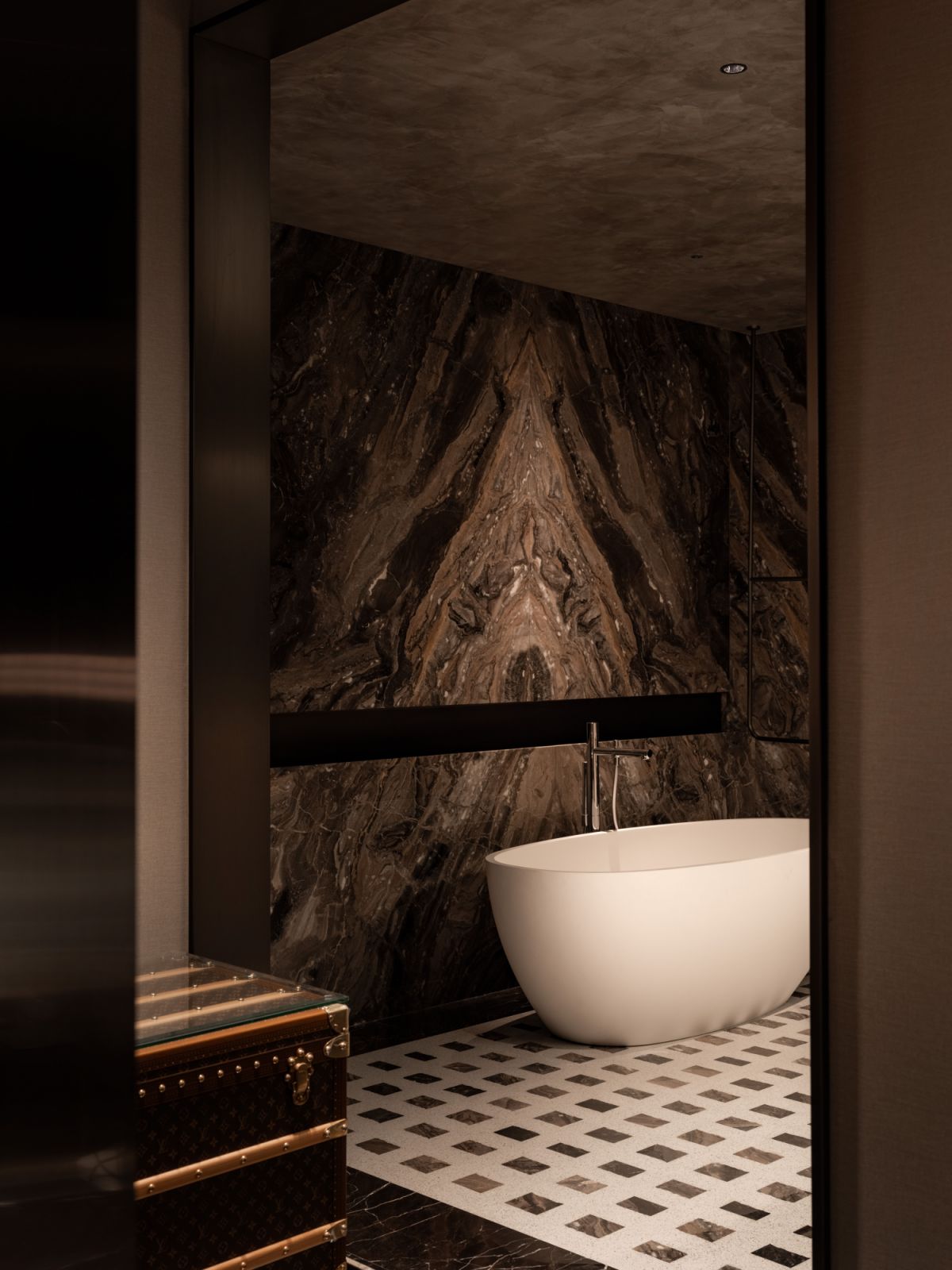 Custom marble patterns replace traditional rugs in the master bathroom