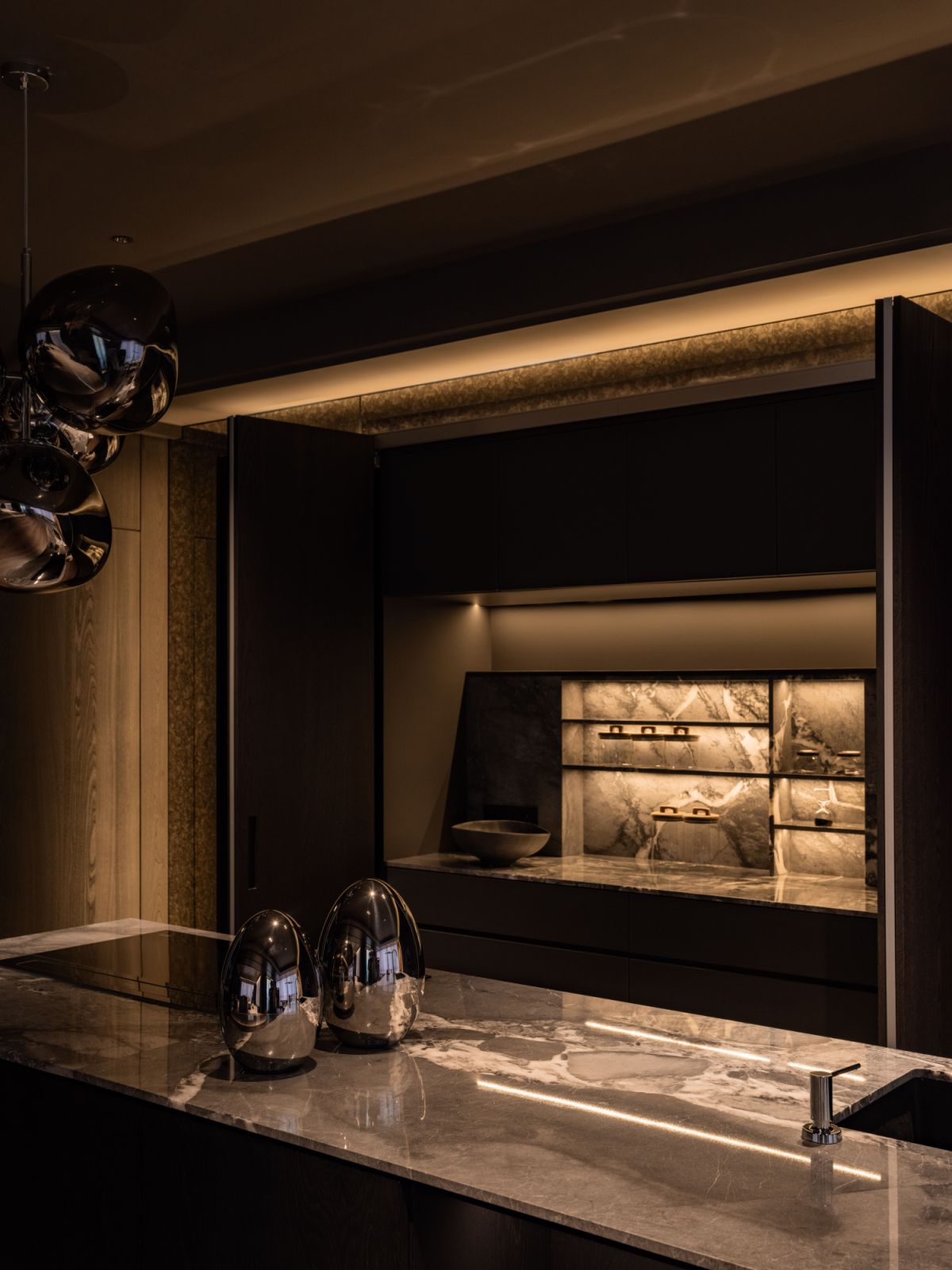 The kitchen’s architectural composition balances visual restraint with material richness