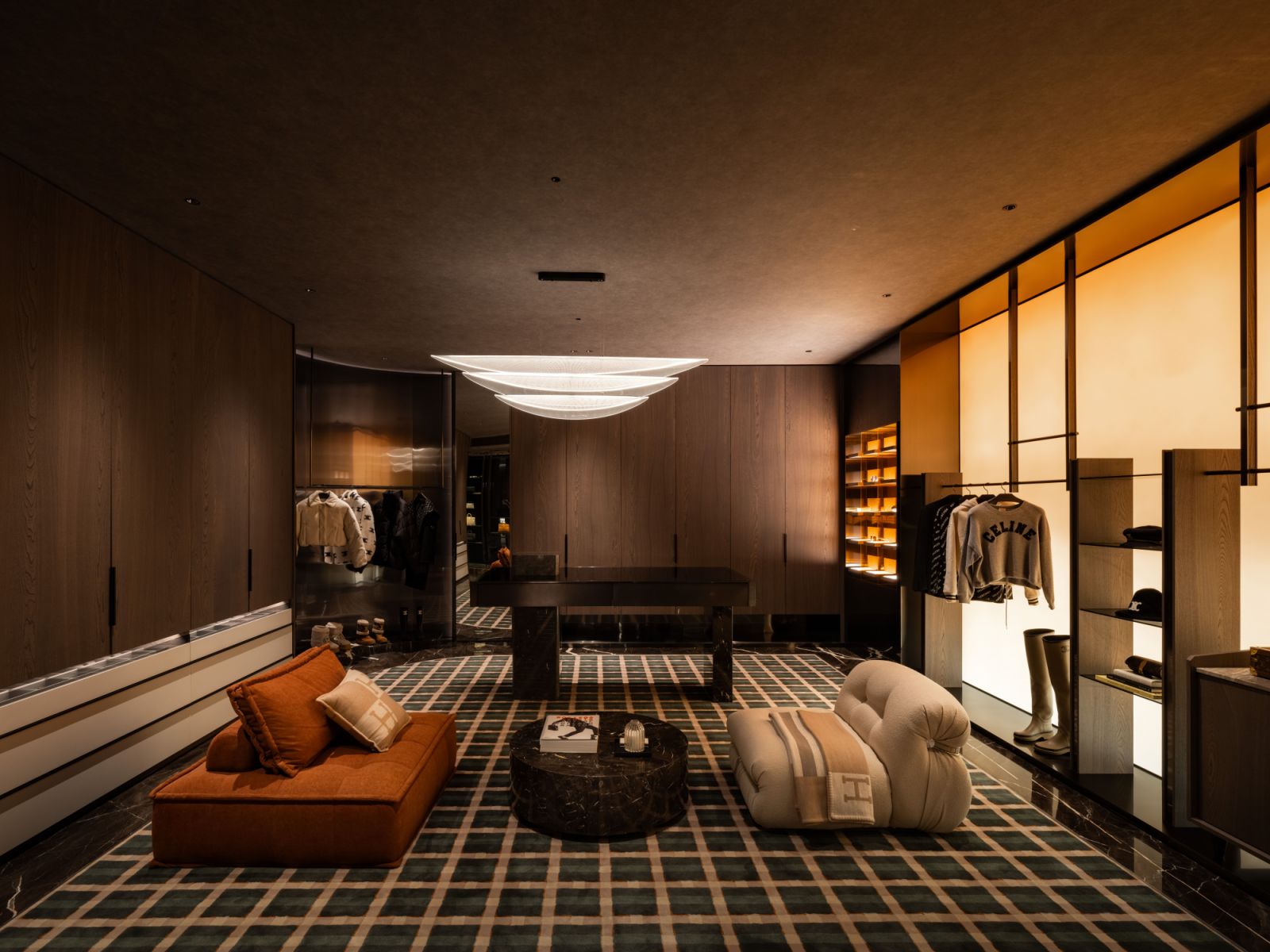 Inspired by luxury retail environments, the walk-in wardrobe features seasonal display systems and curated accessory presentations