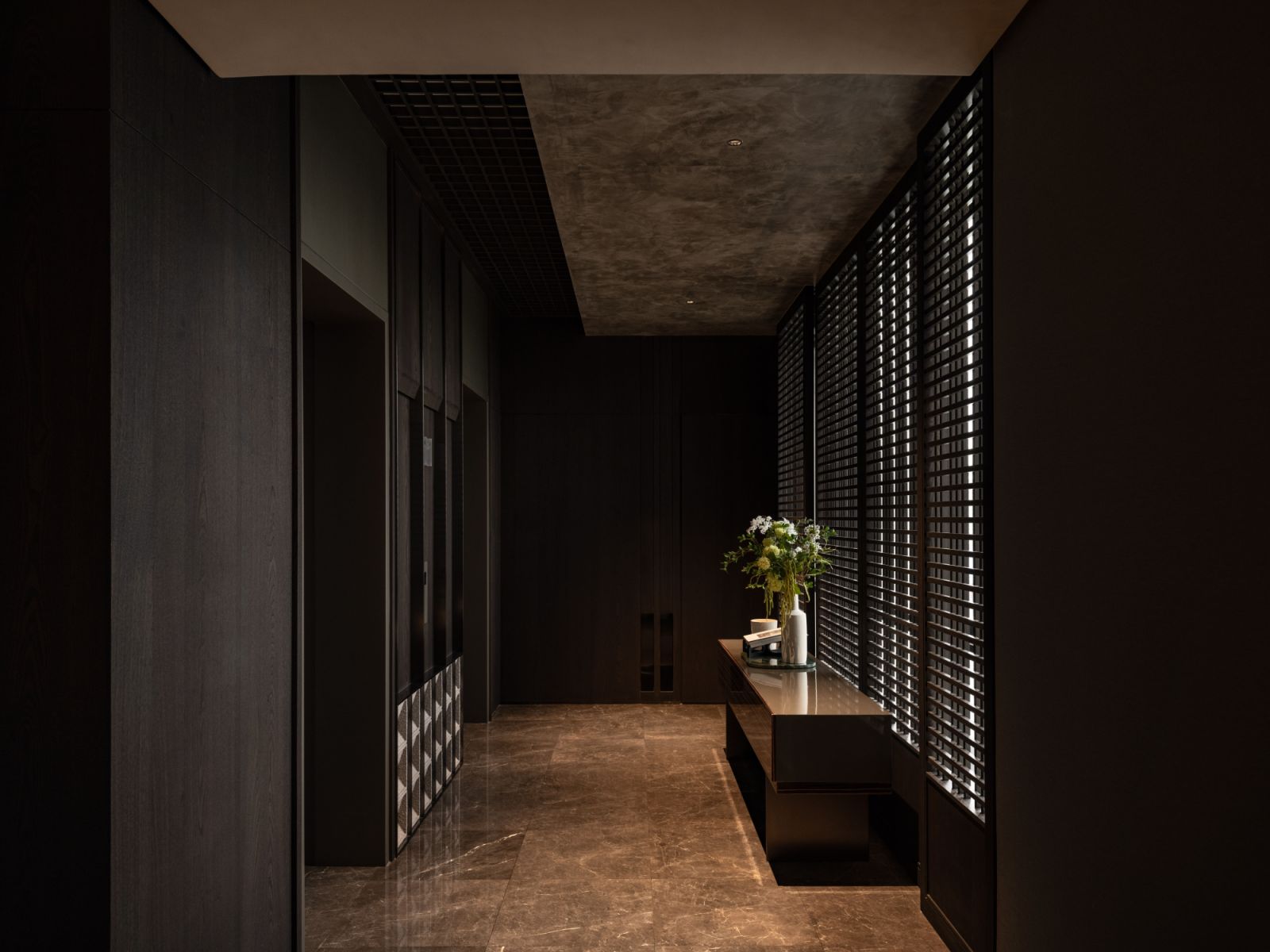 The lift lobby’s wood paneling creates a composed entrance experience