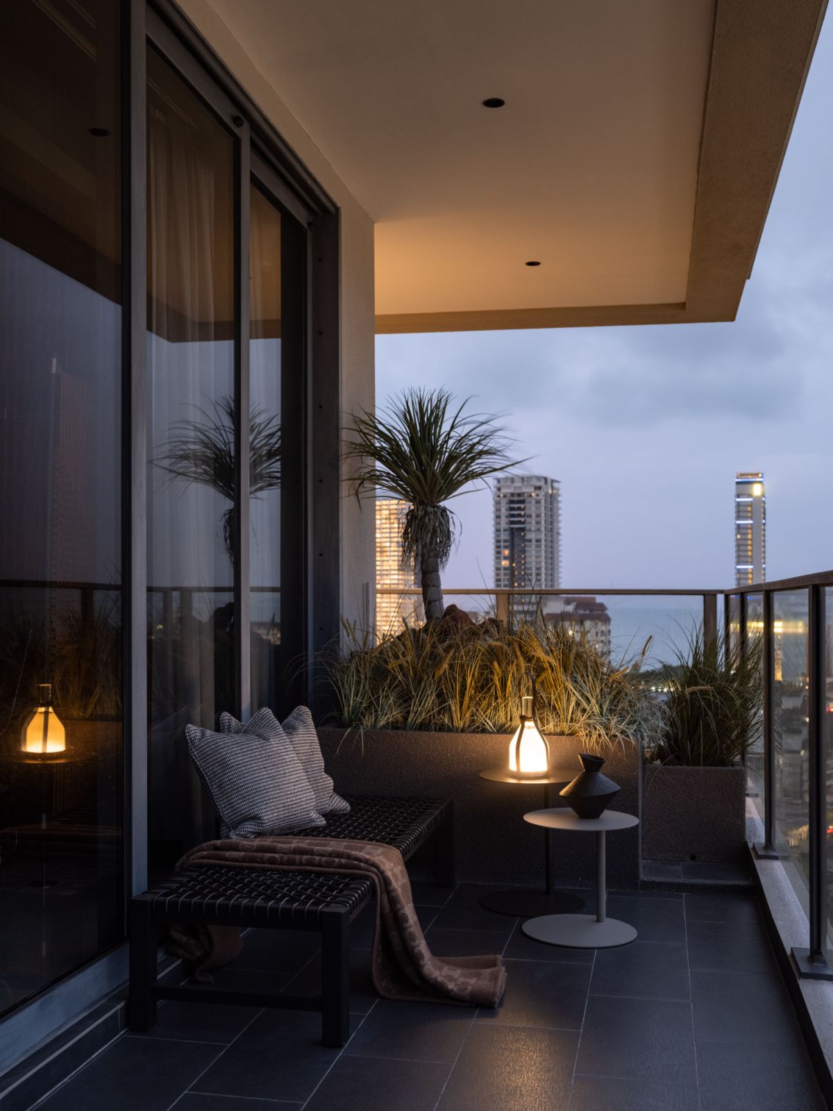 Evening lighting transforms this balcony corner into an intimate outdoor retreat