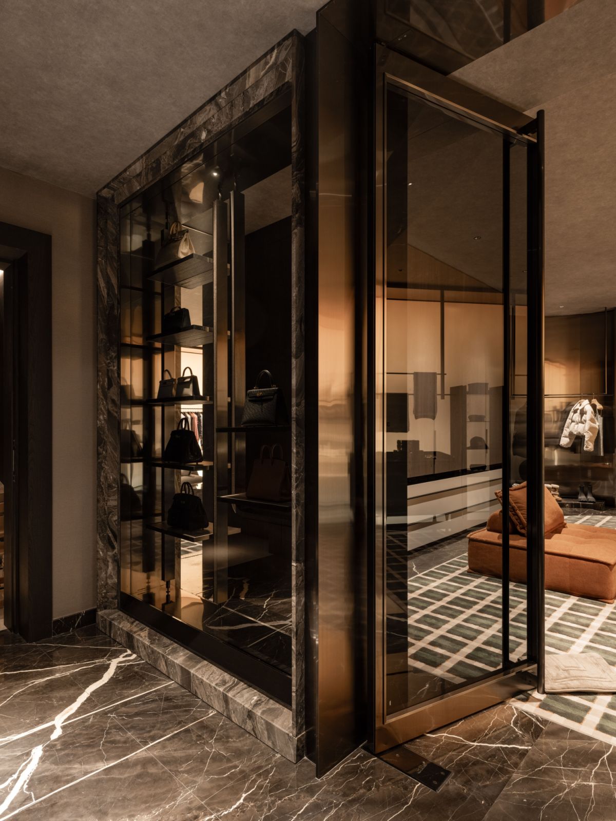 The walk-in wardrobe combines display and storage functions with precise lighting that highlights the owner’s collection