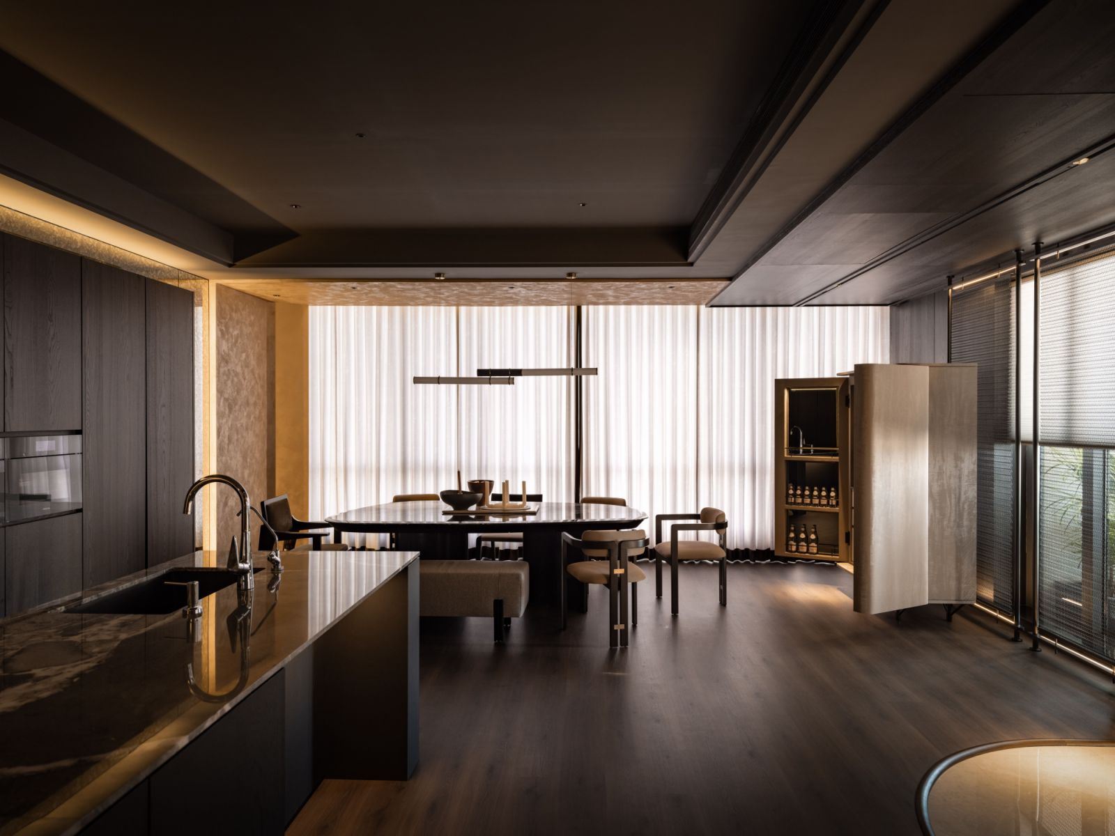 The dining area flows into the dry kitchen, where marble surfaces create visual continuity between both spaces