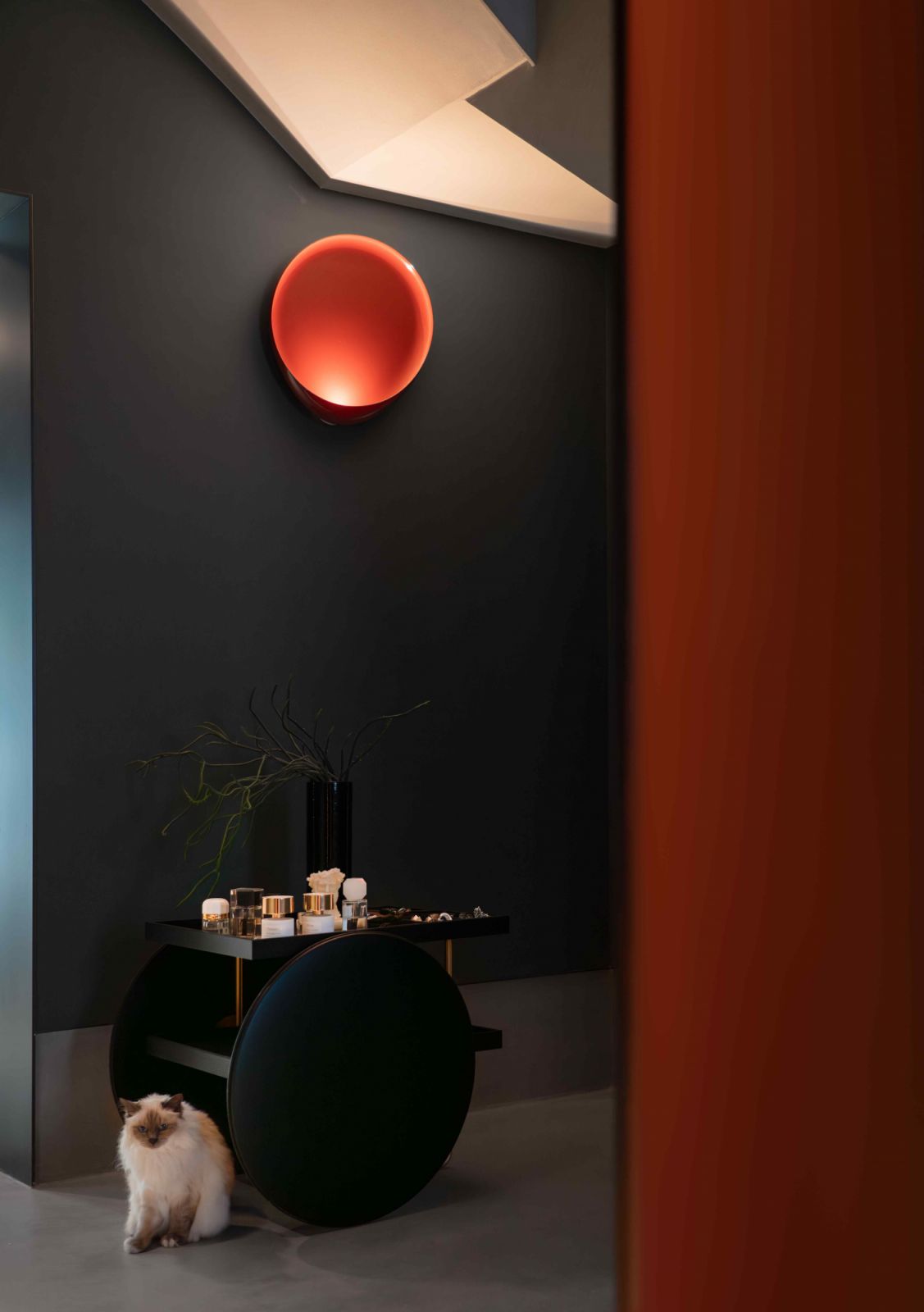 Red accents bring vibrancy to the home with its predominantly dark walls