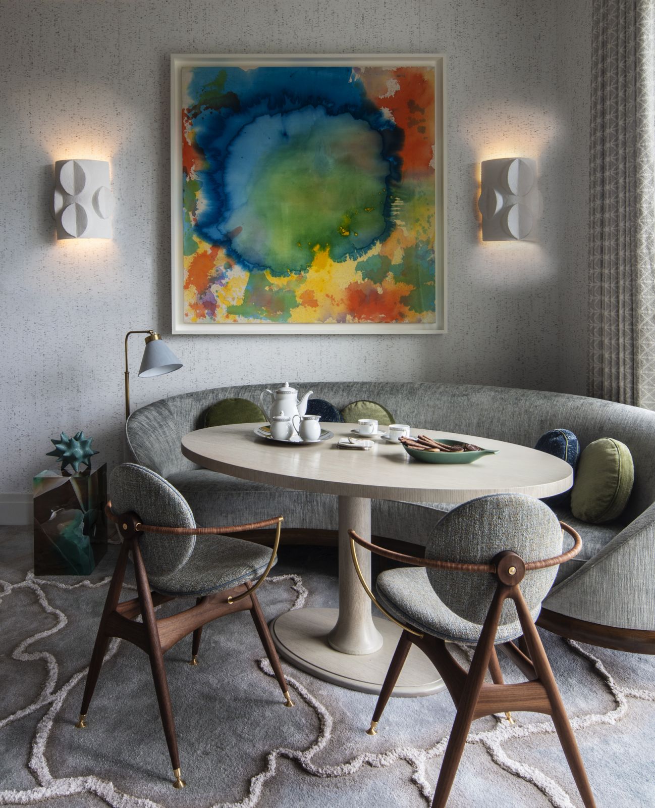 The extension of the primary bedroom, with a side table “EMERALD FISSURE Stone Fossil AP1" by Studio Nucleo via Ammann Gallery and curved sofa by A. Rudin under the artwork “Untitled" by Vivian Springford in a Central Park, New York family home