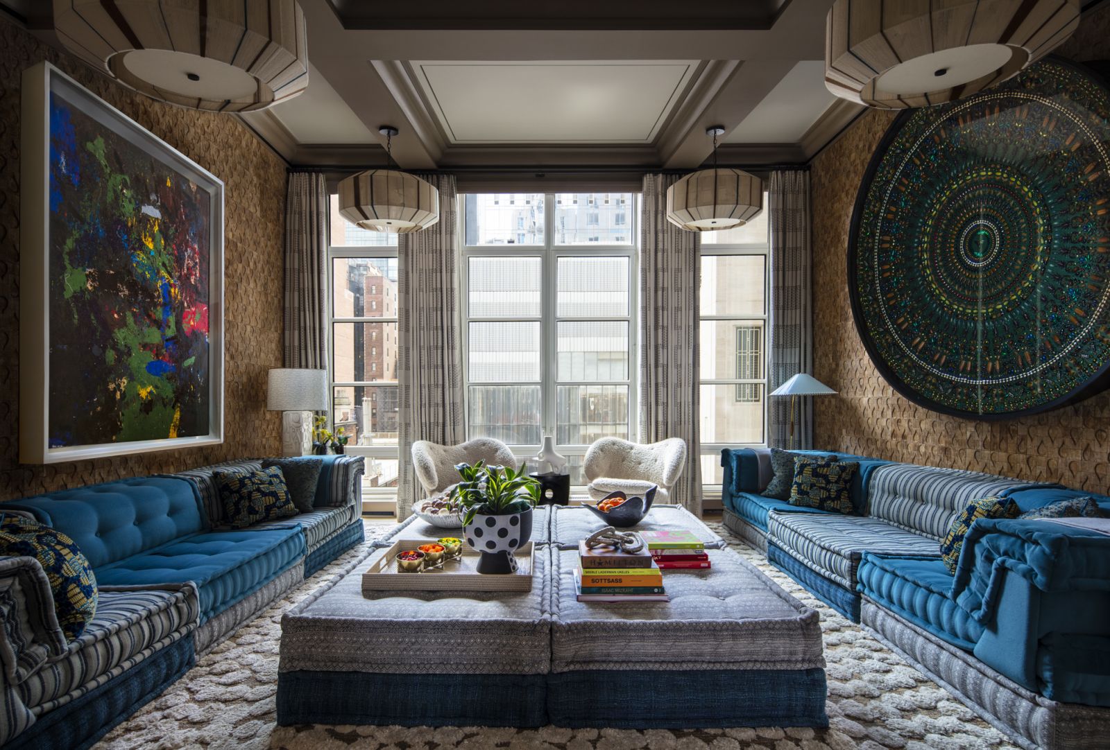 The den, with the abstract painting: “Untitled”, 2018 by Joe Bradley, round mandela artwork “Dark Acheron” by Damien Hirst, “Mah Jong” series of ottomans and sofas by Roche Bobois in a Central Park, New York family home