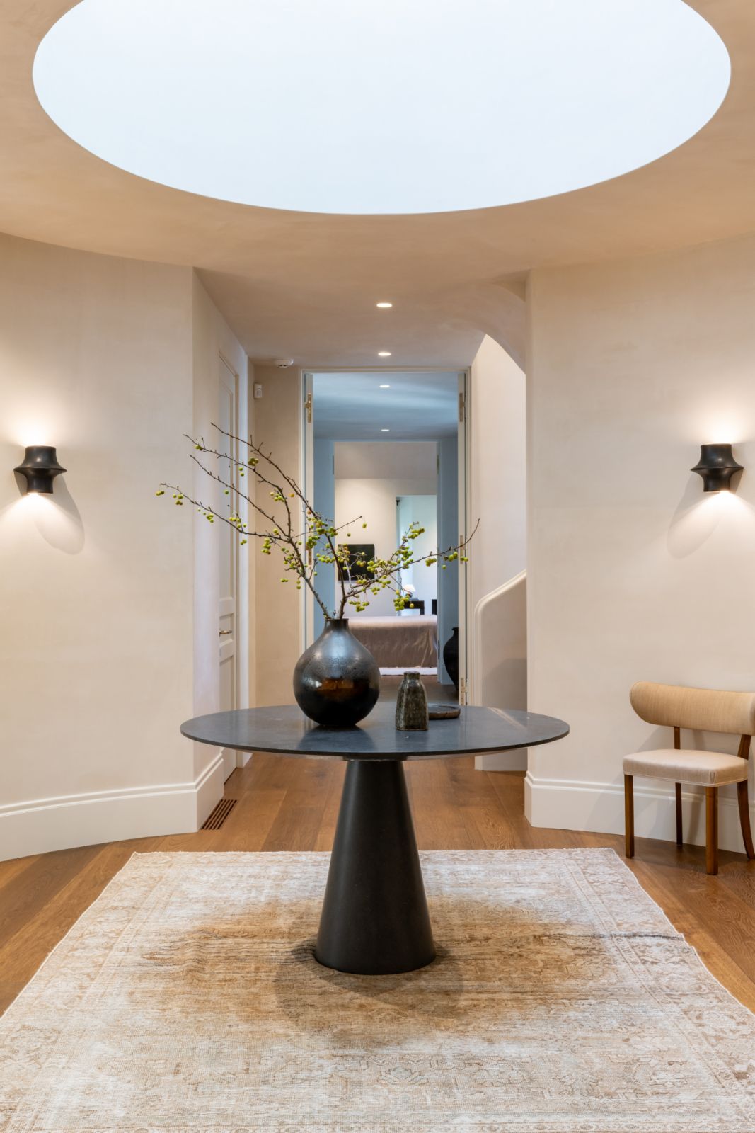The circular skylight in the entry is a striking contemporary feature within an otherwise traditional home