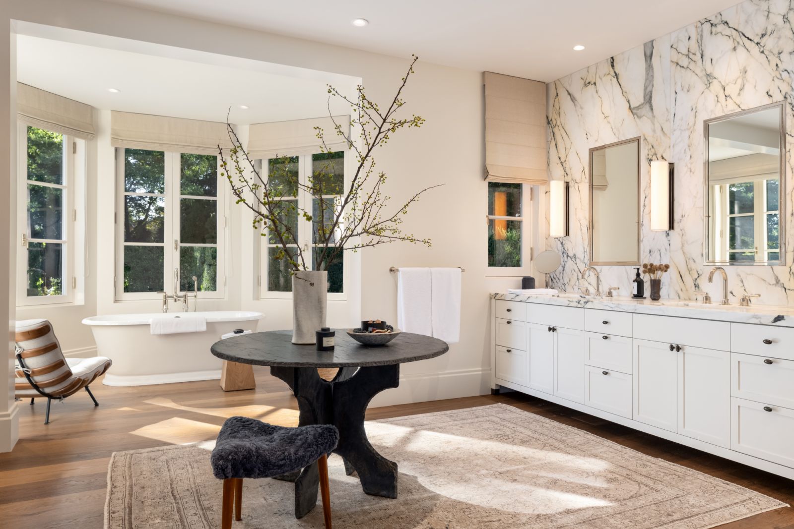 The neutral-coloured main bathroom with marble accents at the vanity