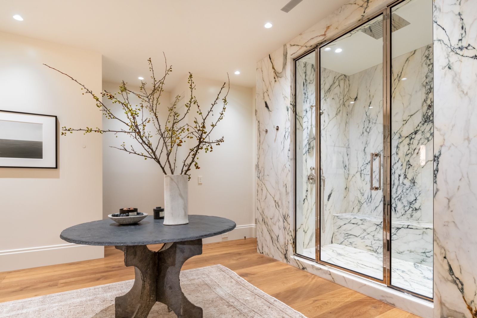 The marble-wrapped shower room adheres to the overarching minimalist design narrative