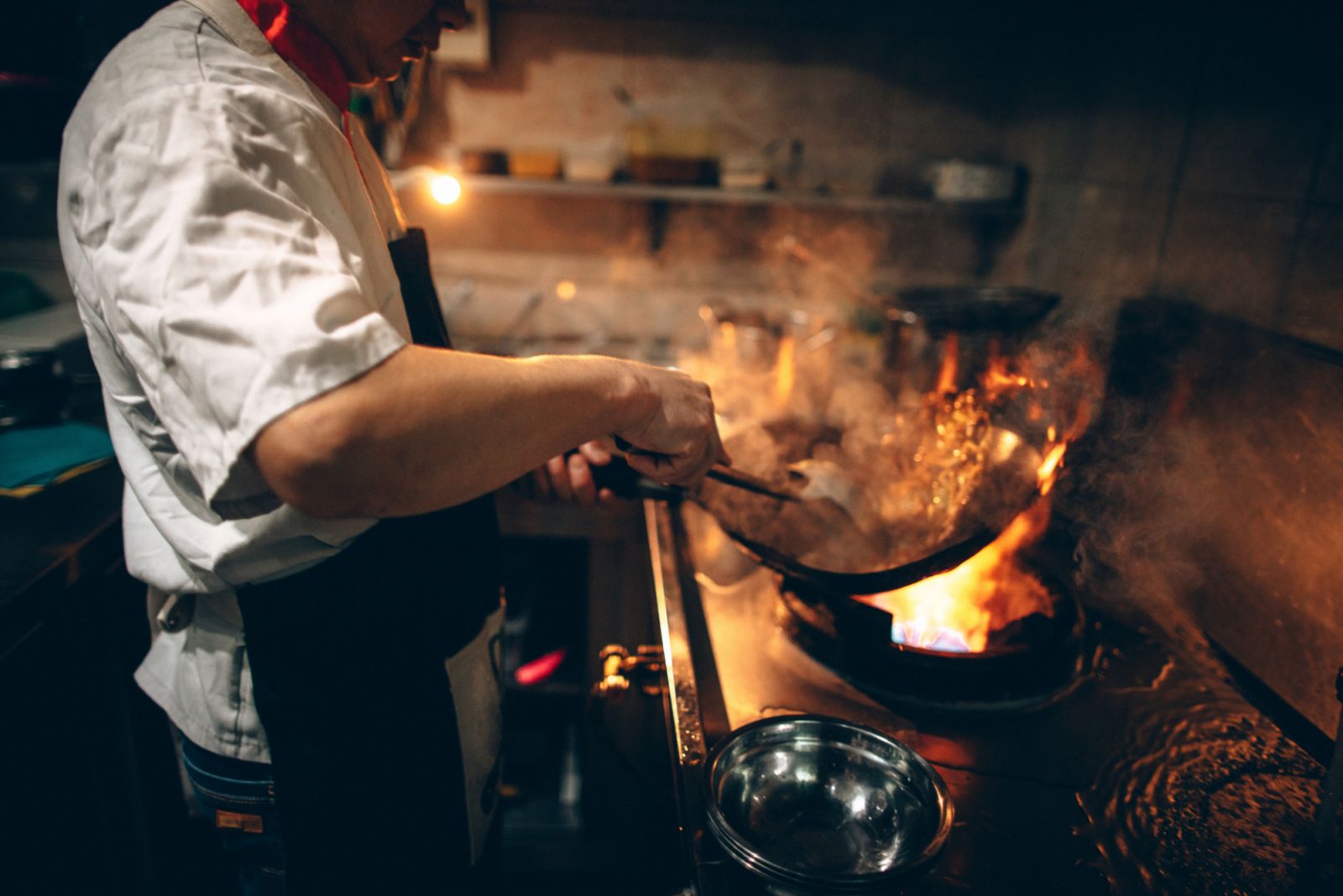 Photo of a Chinese chef preparing food in the kitchen of Chinese restaurant