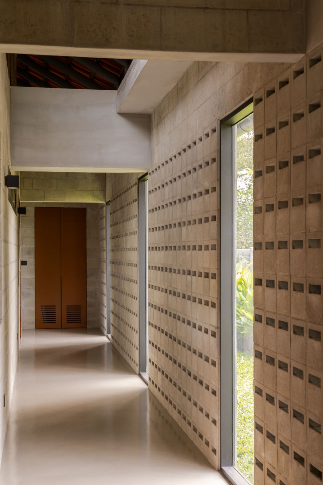 Another view of the corridor shows how the concrete vent blocks create a perforated pattern that allows light and air to filter through