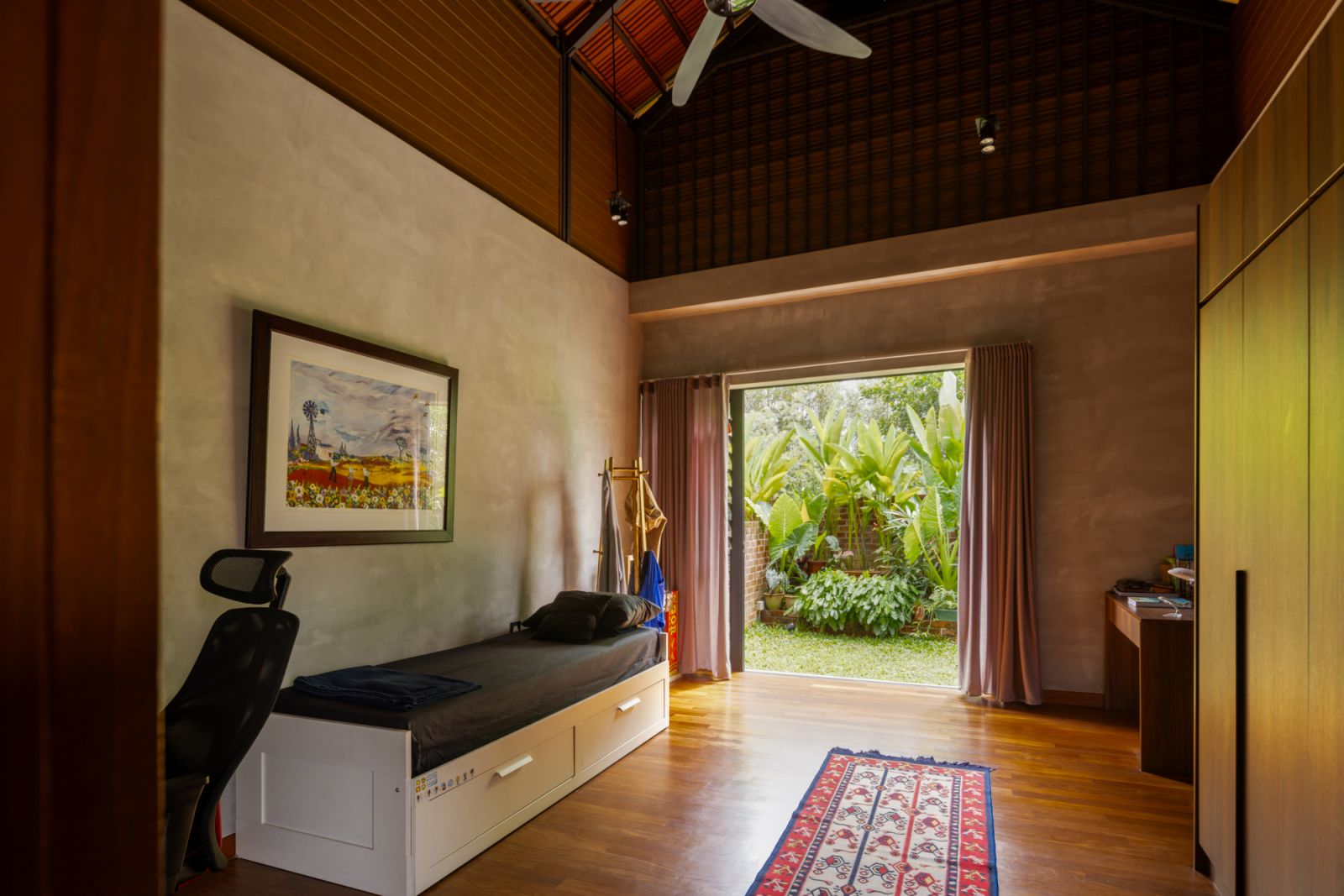A bedroom that exemplifies the home’s connection to nature, with sliding glass doors that open directly to a private garden area