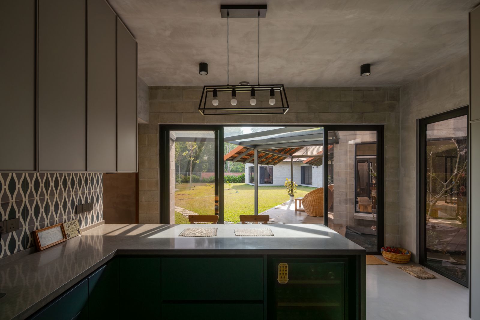 The kitchen opens directly to the garden through full-height sliding glass doors, showcasing the home's indoor-outdoor design philosophy