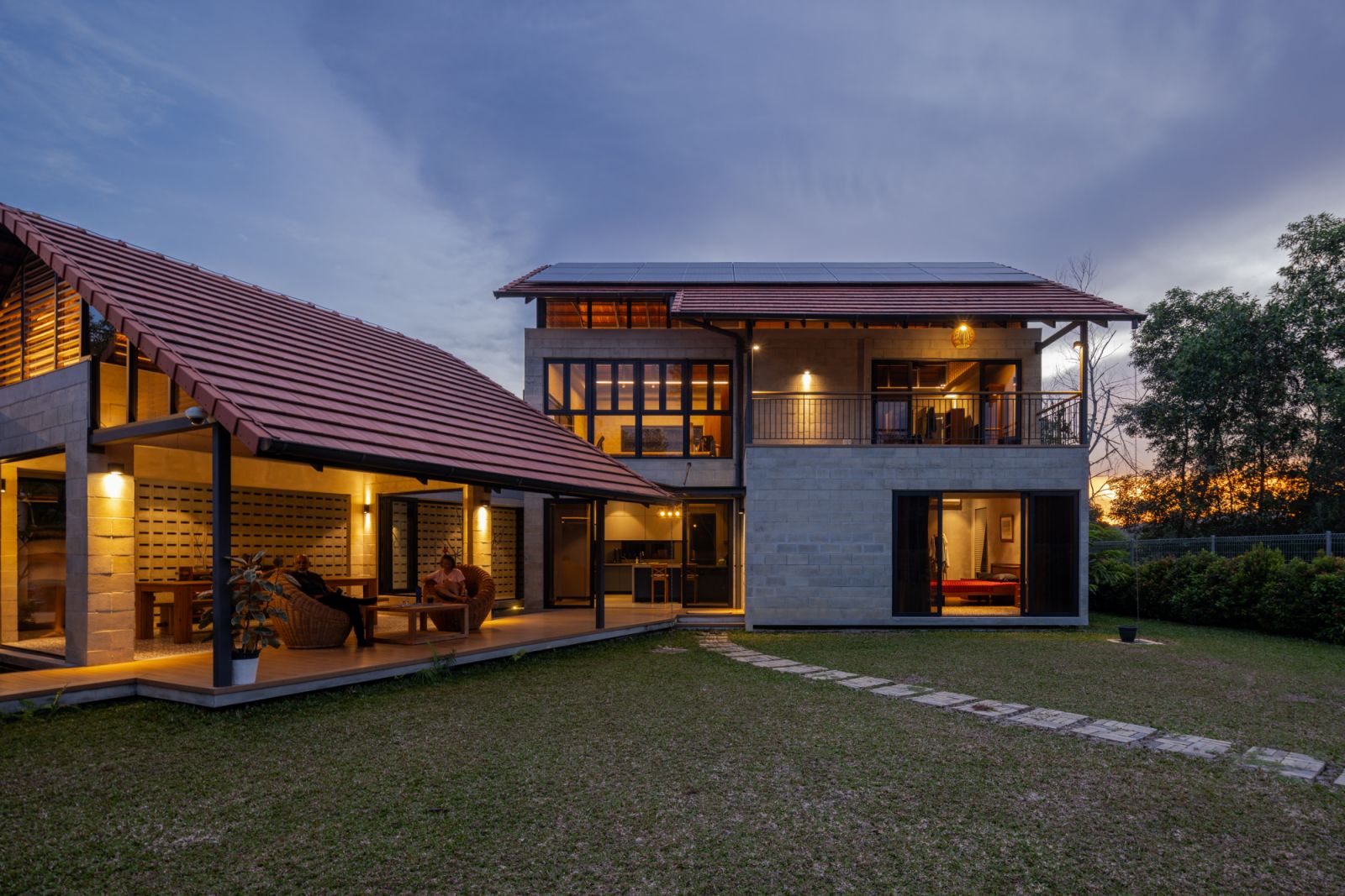 An exterior twilight view reveals the home’s one-and-a-half-storey design that flanks the central garden