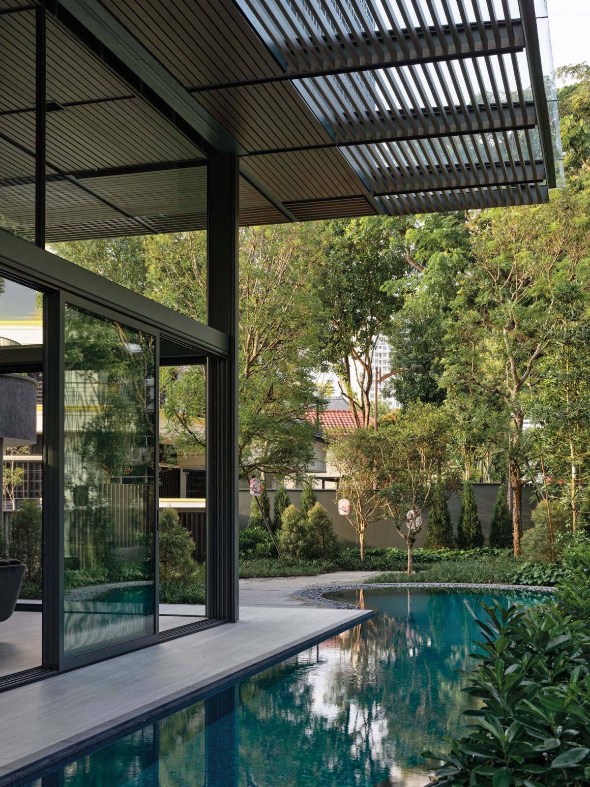 The curvaceous swimming pool evokes a sense of calm and enhances the overall garden-oasis feel