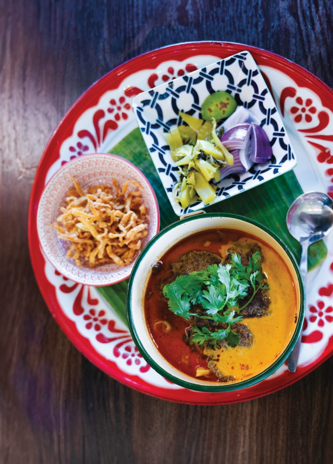 Khao soi is a dish that you rarely find outside of Northern Thailand. It is a must when you are in Northern Thailand. 
It is a coconut curry noodle soup. The broth (Soup) is very rich and thick. 
I had an option of either chicken or beef but noodles were only one kind at the restaurant. 
Toppings are also fun. Usually chopped cilantro, sliced shallots are served.