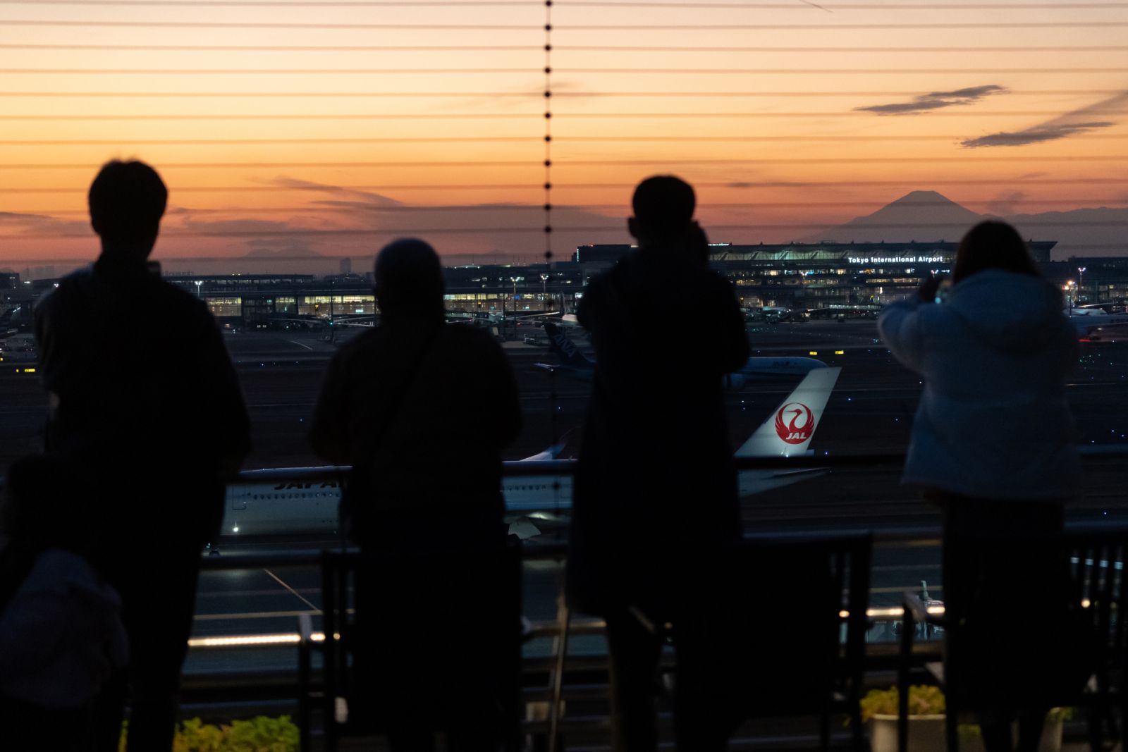 TOKYO, JAPAN - DECEMBER 26: People look at a Japan Airlines (JAL) aircraft taxi-ing at Haneda Airport on December 26, 2024 in Tokyo, Japan. JAL announced the suspension of ticket sales for all flights scheduled on December 26, 2024, following a cyber attack that disrupted its operations and delayed numerous domestic and international flights. The airline reported that it experienced issues with systems interfacing with external networks early in the morning and took immediate action to isolate a problemati