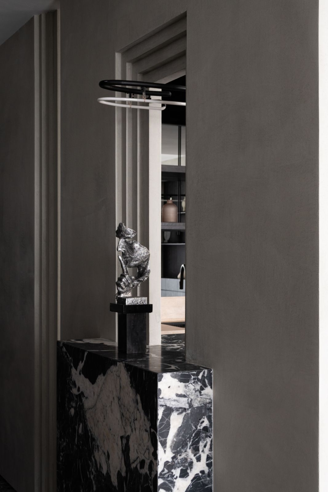 A minimalist console paired with a sculptural flower arrangement creates a moment of calculated contrast at the entrance