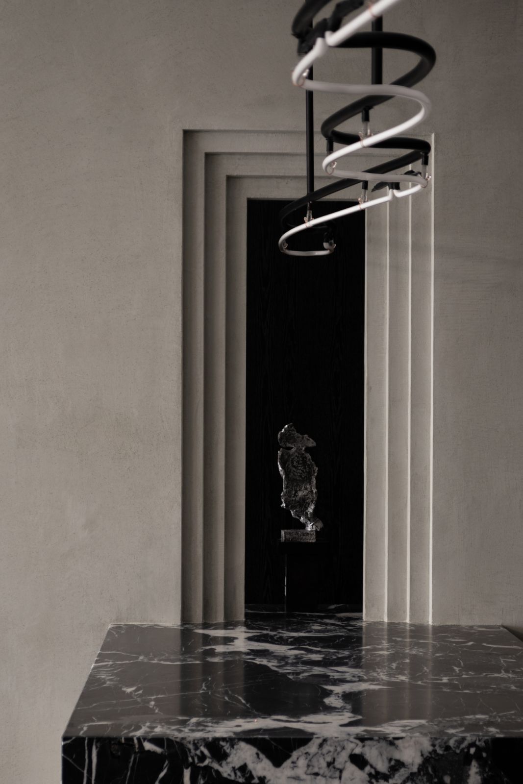 A minimalist console paired with a sculptural flower arrangement creates a moment of calculated contrast at the entrance