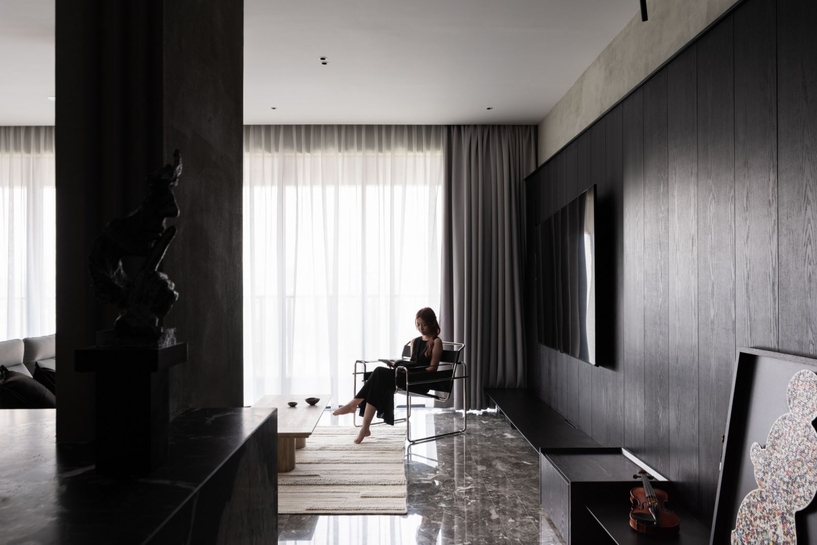 A precisely positioned armchair anchors one corner of the living area