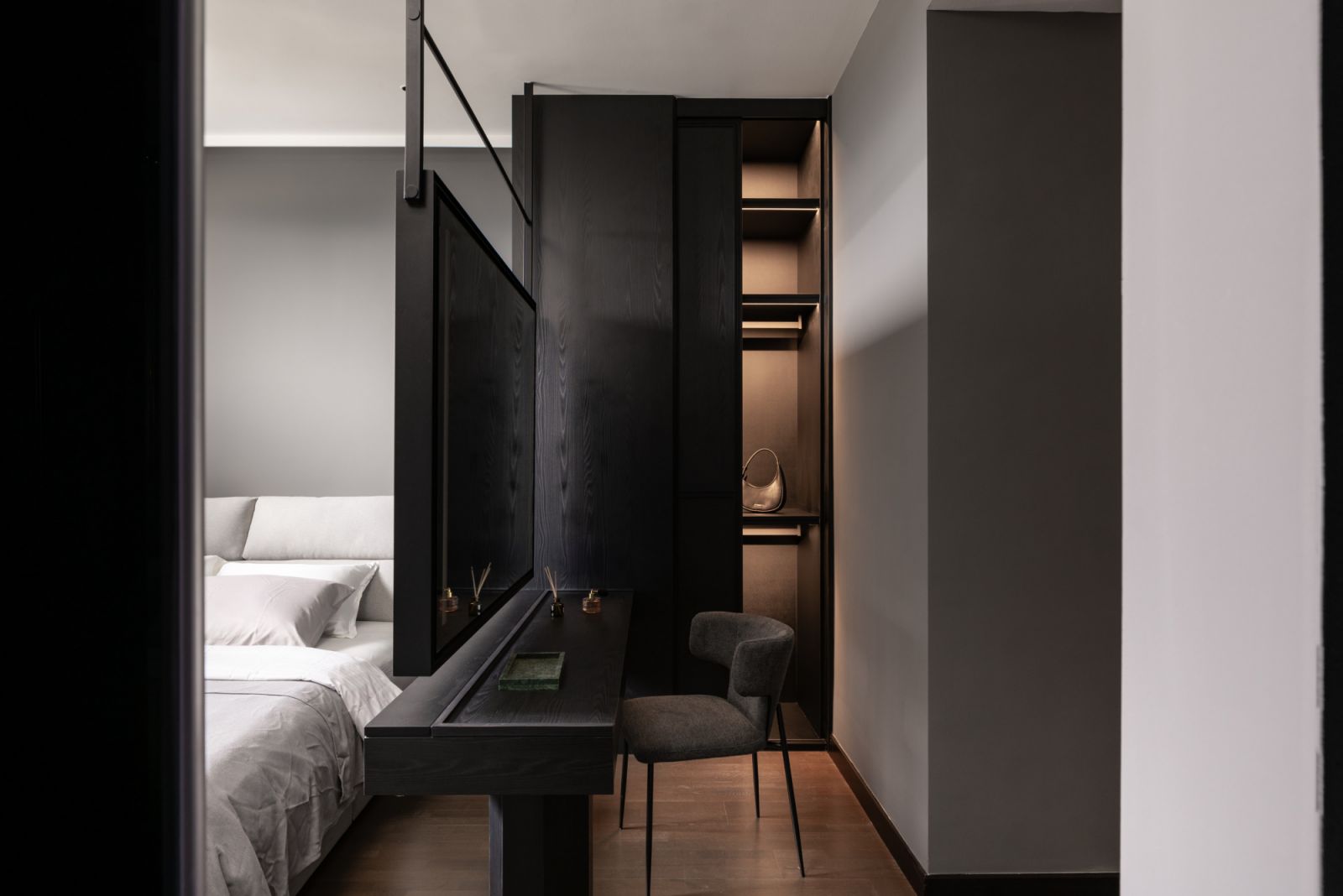 Strategic lighting and dark veneer elements create an intimate retreat